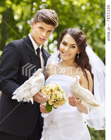 Bride and groom holding dove outdoor. Bride and groom holding dove outdoor. 7855106