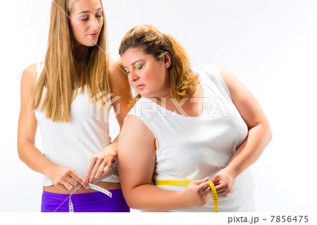 Thin and fat woman measuring waist with tape 7856475