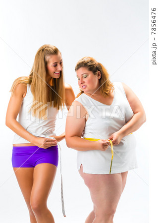 Thin and fat woman measuring waist with tape 7856476