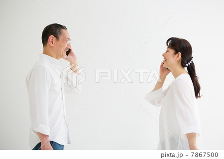 向かい合ってスマートフォンで話をするシニア男女 7867500