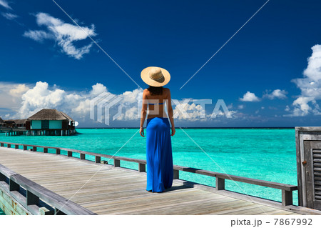 Woman on a beach jetty at Maldives 7867992