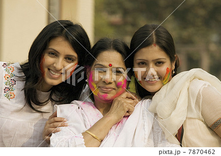 Mother and daughters celebrating Holi  7870462