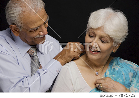 Man putting a necklace around her neck  7871725
