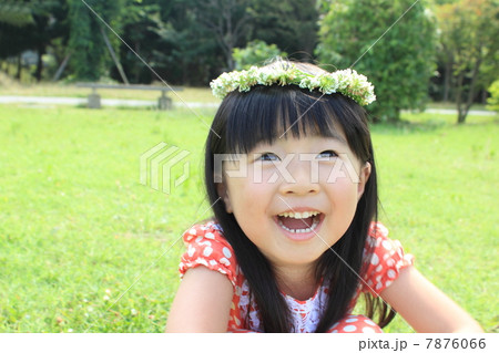 シロツメクサの花冠をかぶった女の子の写真素材