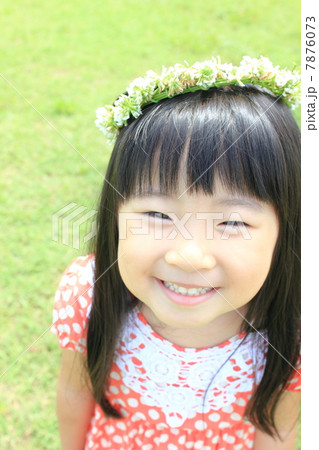 シロツメクサの花冠をかぶった女の子の写真素材