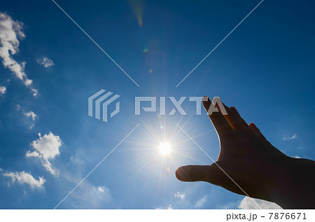 太陽に手を掲げるの写真素材