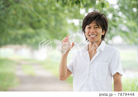 ペットボトルの水を飲む男性の写真素材