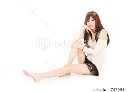 裸足で楽しそうに座ってくつろぐキュートな女の子の写真素材