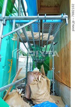木造建築現場の仮設足場と仮設トイレ・縦位置 7882102
