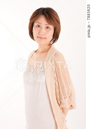 後ろに手を組んで優しい笑顔でポーズを撮る40代の女性 7883620