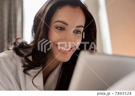 Woman in bathrobe using tablet computer Woman in bathrobe using tablet computer 7893528