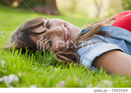 Young woman lying on grass Young woman lying on grass 7893564