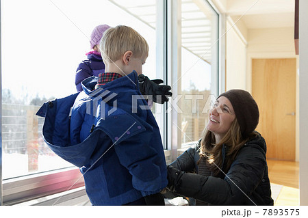 Boy getting dressed in winter clothing, mother helping Boy getting dressed in winter clothing, mother helping 7893575