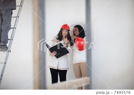 Architect and designer discussing plans on construction site 7893576