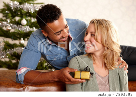 Man giving girlfriend Christmas present Man giving girlfriend Christmas present 7893595