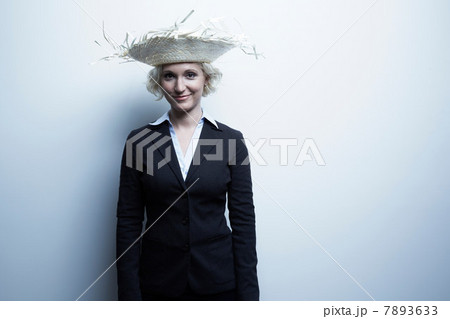 Studio portrait of blond businesswoman wearing straw hat Studio portrait of blond businesswoman wearing straw hat 7893633