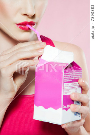 Young woman drinking carton of milk through straw 7893883