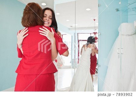 Daughter trying on wedding dress, embracing mother Daughter trying on wedding dress, embracing mother 7893902
