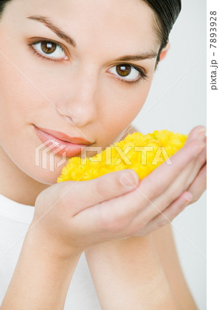 Portrait of young brunette woman holding yellow petals 7893928