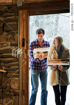 Mid adult couple holding logs Mid adult couple holding logs 7893929