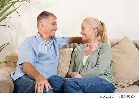 Mature couple sitting on sofa 7894037