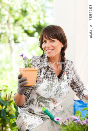 Woman potting plants outdoors Woman potting plants outdoors 7894103