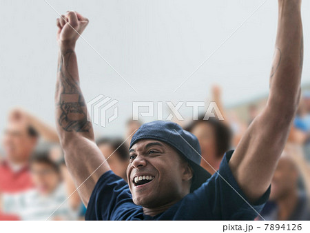 Man at sports game with arms raised Man at sports game with arms raised 7894126