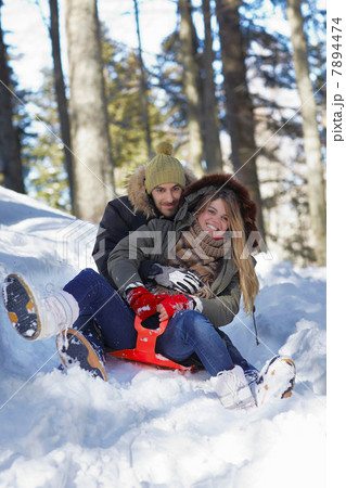 Couple tobogganing in snow Couple tobogganing in snow 7894474