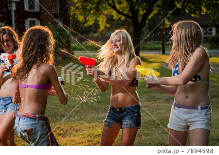 Girls having water fight with water pistols 7894598