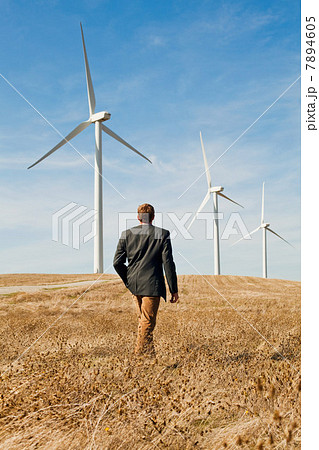 Man walking in front of wind turbines Man walking in front of wind turbines 7894605