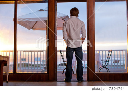 Man standing in doorway of patio Man standing in doorway of patio 7894744