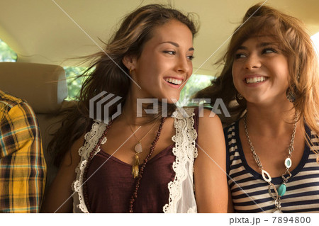 Two female friends in backseat of car Two female friends in backseat of car 7894800