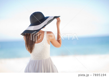 Woman wearing floppy hat on beach 7895194