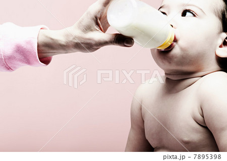 Portrait of baby girl drinking milk from bottle 7895398