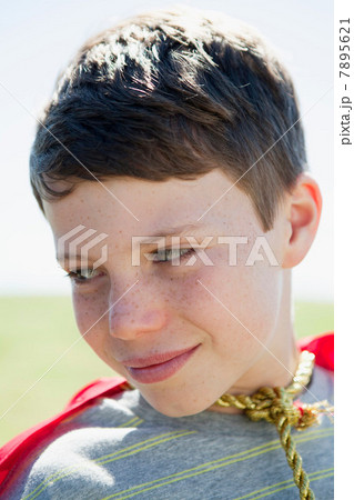 Boy wearing super hero cape, close up portrait 7895621