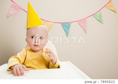 Baby boy sitting in highchair with bunting 7895622