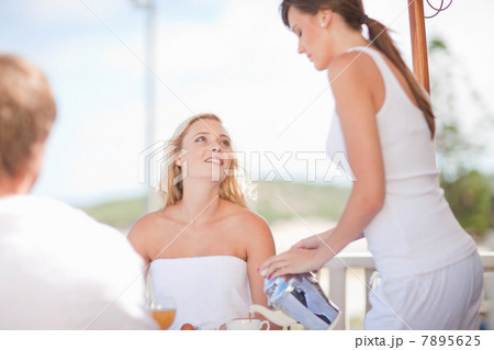 Waitress serving woman coffee at table 7895625