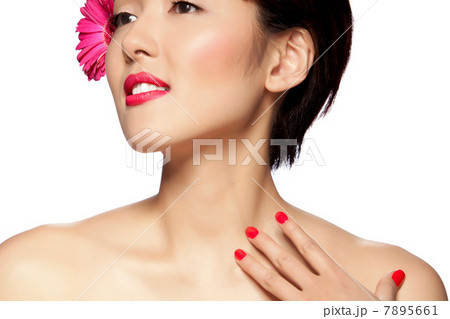 Young woman wearing pink flower in hair against white background Young woman wearing pink flower in hair against white background 7895661