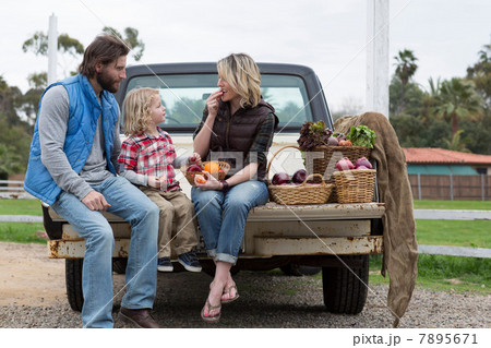 Family with produce in truck bed 7895671