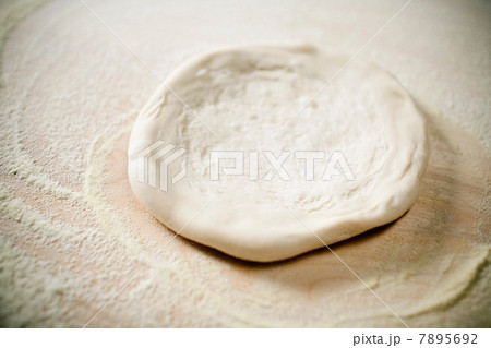 Close up of pizza dough being flattened 7895692