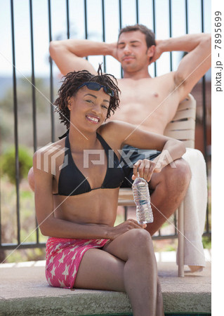 Couple relaxing by swimming pool Couple relaxing by swimming pool 7895699