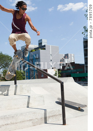 Skateboarder jumping over a rail 7895709