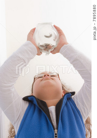 Young girl holding piggy bank, low angle 7895880