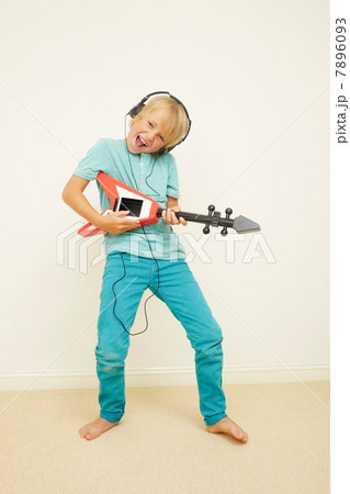 Boy wearing headphones playing guitar 7896093