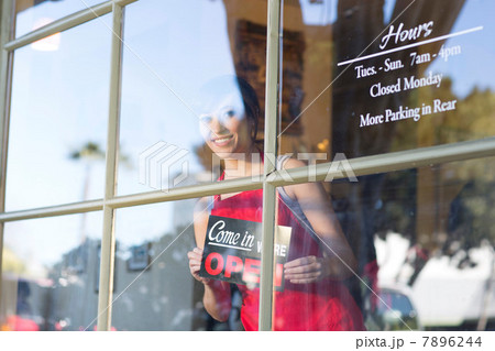 Waitress putting open sign in window 7896244