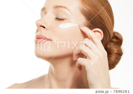 Woman applying moisturiser with eyes closed 7896261