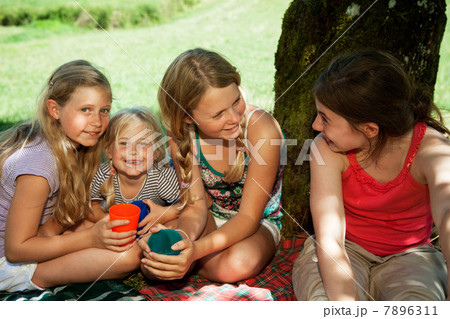 Four children sitting on picnic blanket 7896311