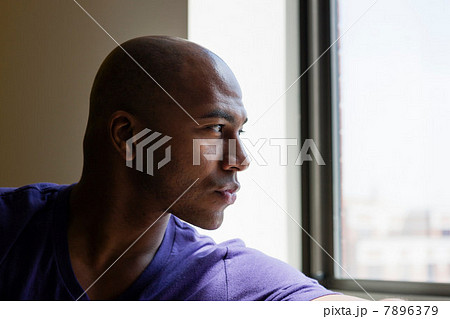 Close up portrait of mid adult male looking out of window 7896379