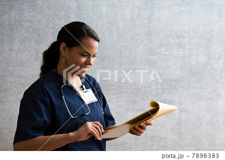 Hospital nurse looking at medical chart 7896383