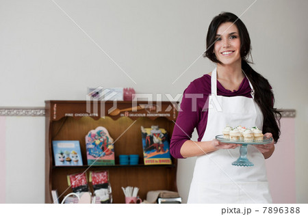 Baker holding tray of cupcakes Baker holding tray of cupcakes 7896388